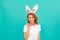 positive easter girl in bunny ears and bow tie on blue background