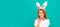 positive easter girl in bunny ears and bow tie on blue background. Woman isolated face portrait, banner with mock up