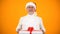Positive elderly man in Santa hat holding gift box, best presents shop ad