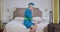 Positive elegant Caucasian stewardess dialing number on the phone in hotel room. Portrait of confident young blond woman