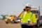positive employee construction man in vest protective hardhat talk on phone with lunch outdoor, copy space. construction