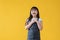 A positive and excited little Asian girl is standing against an isolated yellow background