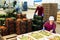 Positive female employee of vegetable sorting factory arranging tomatoes in boxes