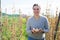 Positive female farmer cultivating organic peas