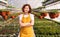 Positive female farmer in greenhouse