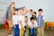 Positive female teacher playing circle game with children in classrom