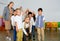 Positive female teacher playing circle game with children in classrom