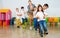 Positive female teacher playing circle game with children in classrom