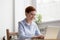 Positive female worker using laptops typing message