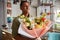 Positive florist store manager staring outside with a bouquet