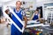 Positive foreman in blue overalls fun demonstrating window frame in factory