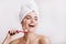 Positive girl without make-up cute smiles on white background. Woman after shower brushing her teeth.