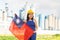 Positive girl in overalls with Taiwan flag in her hands against the background of chimneys of modern factory