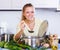 Positive girl preparing veggie soup at home