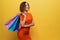 Positive girl with short hair keeping colorful paper bags