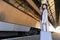 Positive girl with suitcase walks on the platform of the railway station near train car.