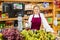 Positive girl who works part-time as a trainee saleswoman at checkout counter