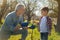 Positive grandfather planting a tree with little grandson