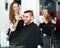 Positive hairdresser working in beauty salon