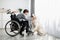 Positive handicapped adolescent playing with his dog, petting golden retriever at home