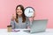 Positive happy woman office worker showing thumbs up holding big wall clock, looking at camera with toothy smile, time management