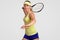 Positive healthy active sporty woman warms up before match, dressed in casual outfit, ready to hit ball with raquet, poses against