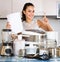 Positive housewife with paper and multicooker