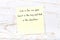 Positive inspiring quote handwritten on sticky note on wooden background