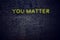 Positive inspiring quote on neon sign against brick wall you matter