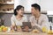 Positive japanese spouses having snack at home, shopping online