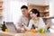 Positive japanese spouses watching culinary vlog while cooking