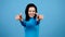Positive joyful cheerful woman showing thumbs up on blue background