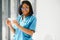 Positive joyful young African American woman pharmacist or doctor, holding in hands pills.