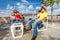 Positive kids sit on white chairs with skateboards