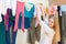 Positive long-haired girl drying clothes on clothes-line