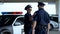 Positive male and female police officers communicating on parking lot, on duty