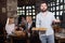 Positive male waiter welcoming guests to country restaurant