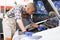 Positive man car mechanician repairing car in auto repair service