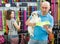 Positive man with dog looking bowl in pet store