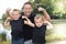 Positive man father and little boy son with raised arms show biceps in black t-shirt