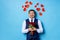 Positive man in tux with red roses isolated over blue background