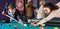 Positive man and young woman hit one ball in billiards
