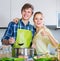 Positive married couple cooking vegetable soup