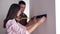 Positive married couple with tape measure in hands hanging shelf on wall after repair in apartment