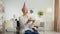 Positive mature woman with disability wearing party cap blowing candles on birthday cake and smiling to camera, zoom in