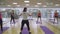 Positive mid-adult Caucasian man showing asana to group of people in gym. Portrait of professional Caucasian yoga