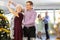 Positive middle-aged man dancing playful Latin dance bachata with mature female partner during celebration Christmas and