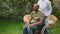 Positive military man smiling as unrecognizable nurse pushing wheelchair. Portrait of optimistic African American