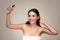 Positive millennial european woman apply spray on hair or skin, enjoy beauty care
