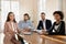 Positive millennial multiethnic startup team sitting at meeting table